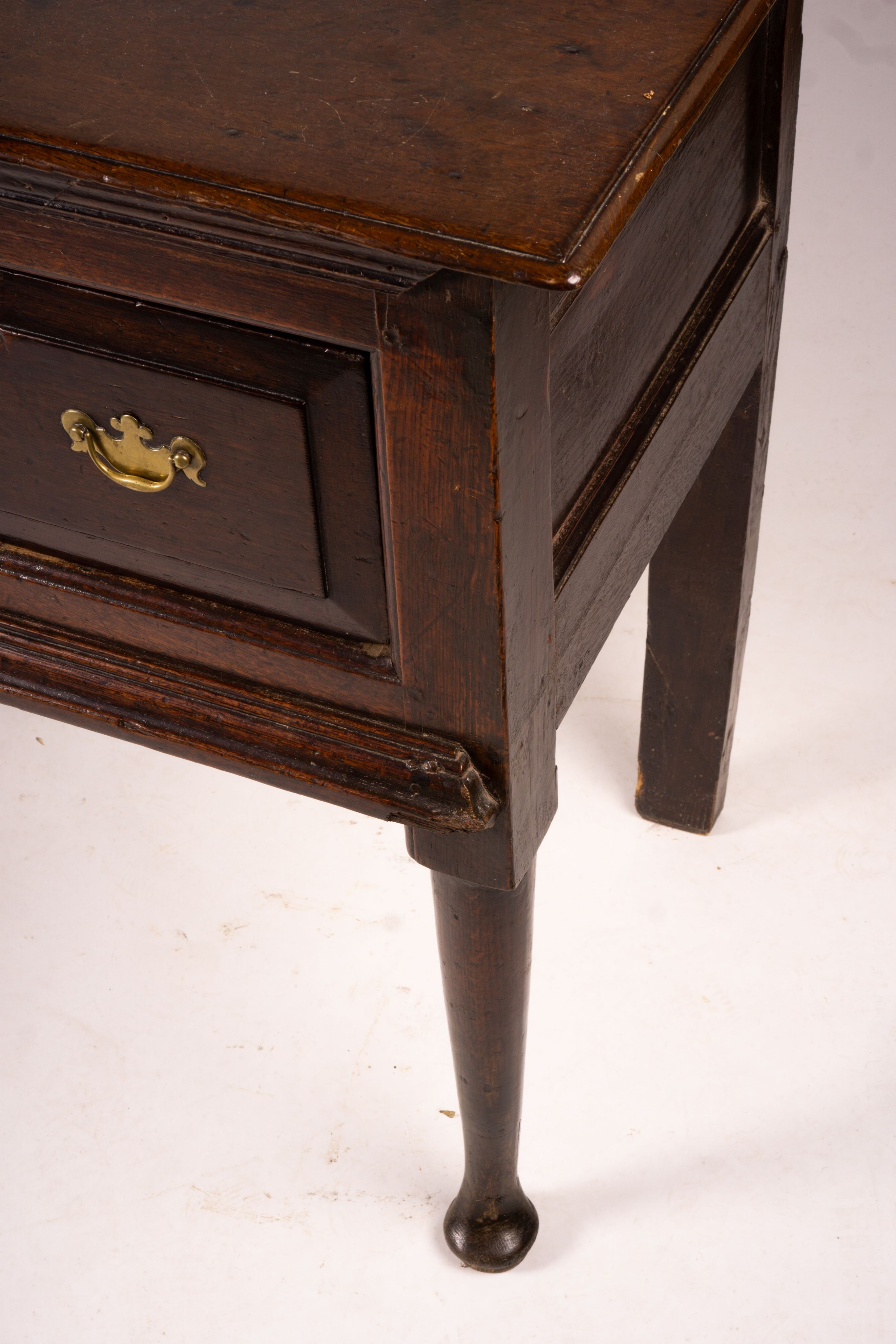 An 18th century oak low dresser on pole turned legs and pad feet, length 198cm, depth 53cm, height 88cm